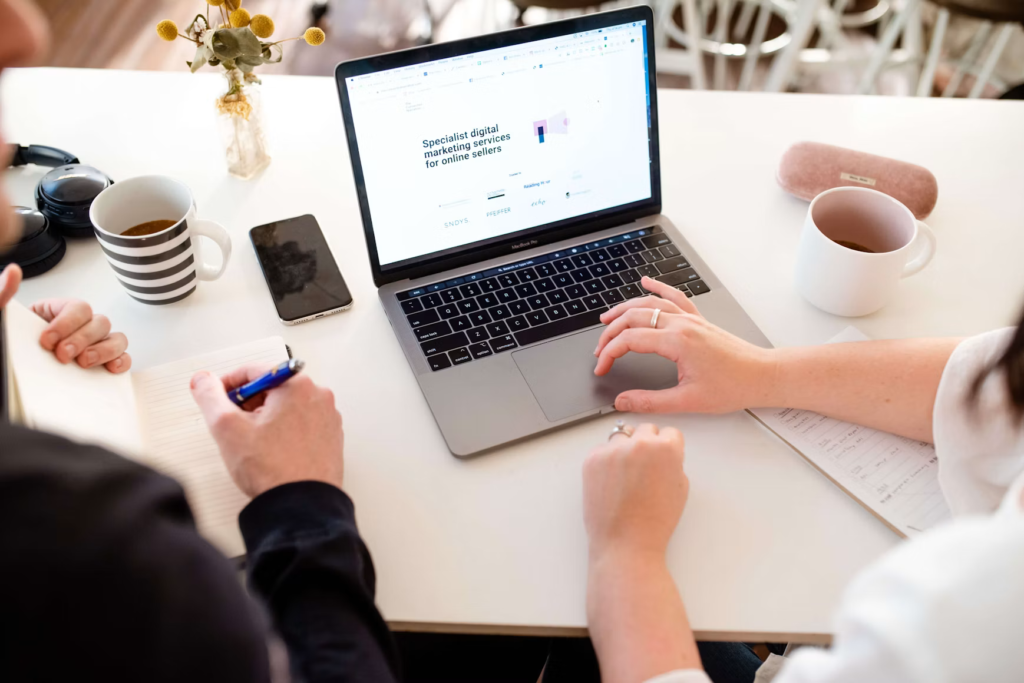 Two people reviewing a business website on a laptop