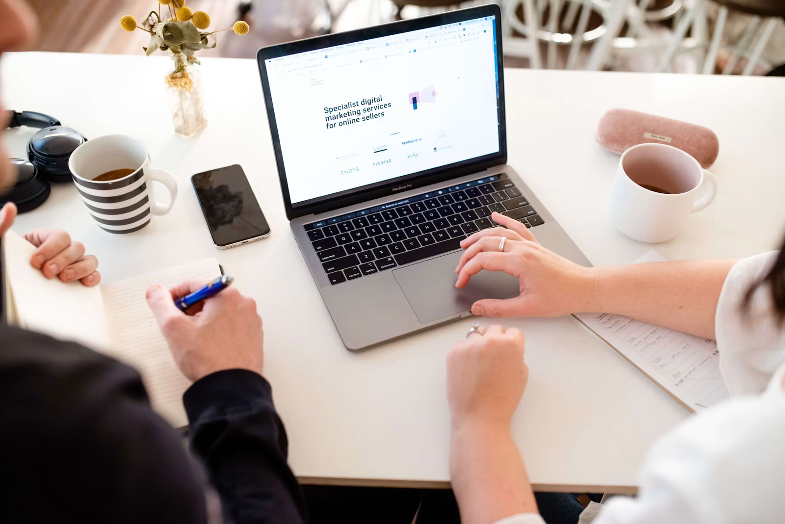 Two people reviewing a business website on a laptop